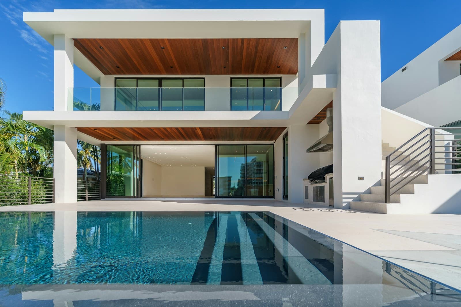 Modern white residential villa with a reflecting pool, shot in bright architectural daylight